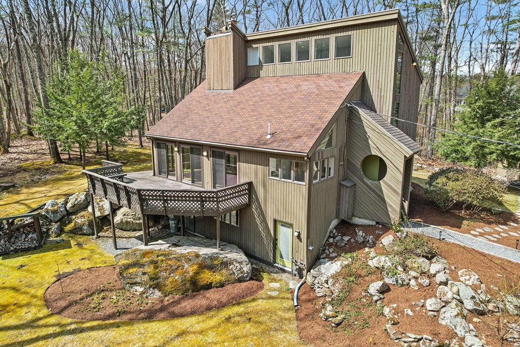 222 Davidson Road Boxborough, MA 01719 - Photo 5 of 16 a view of a house with pool chairs and wooden fence