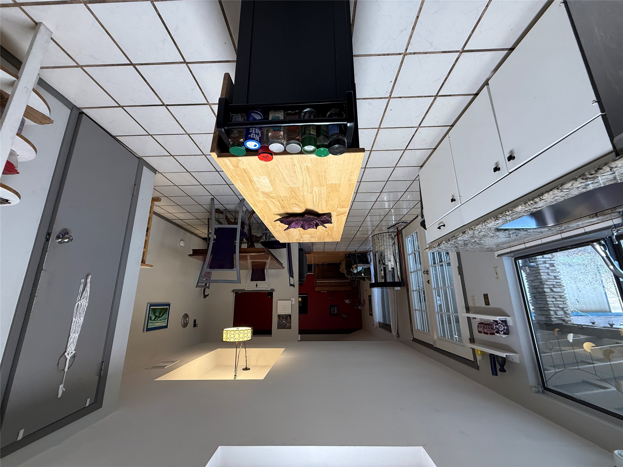 7501 West Gate Boulevard Austin, TX 78745 - Photo 7 of 33 Kitchen with white cabinets, hanging light fixtures, a tray ceiling, light tile patterned floors, and french doors