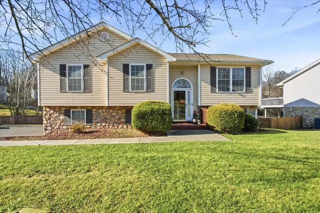 a front view of a house with a garden and trees