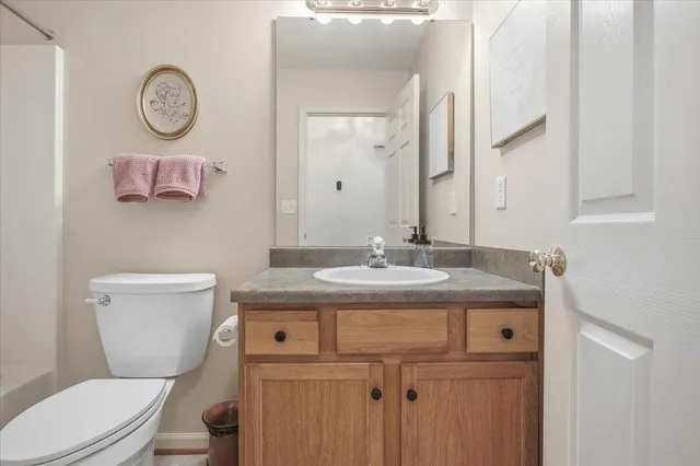 a bathroom with a granite countertop sink a toilet and shower