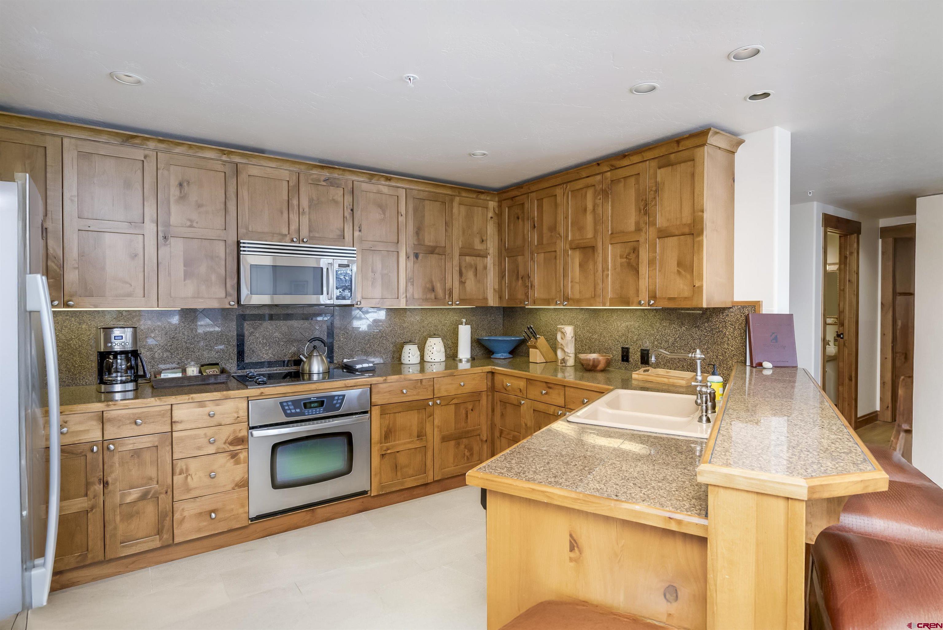 14 Hunter Hill Road, Unit C302 Crested Butte, CO 81225 - Photo 11 of 32 a kitchen with a stove a sink and a microwave