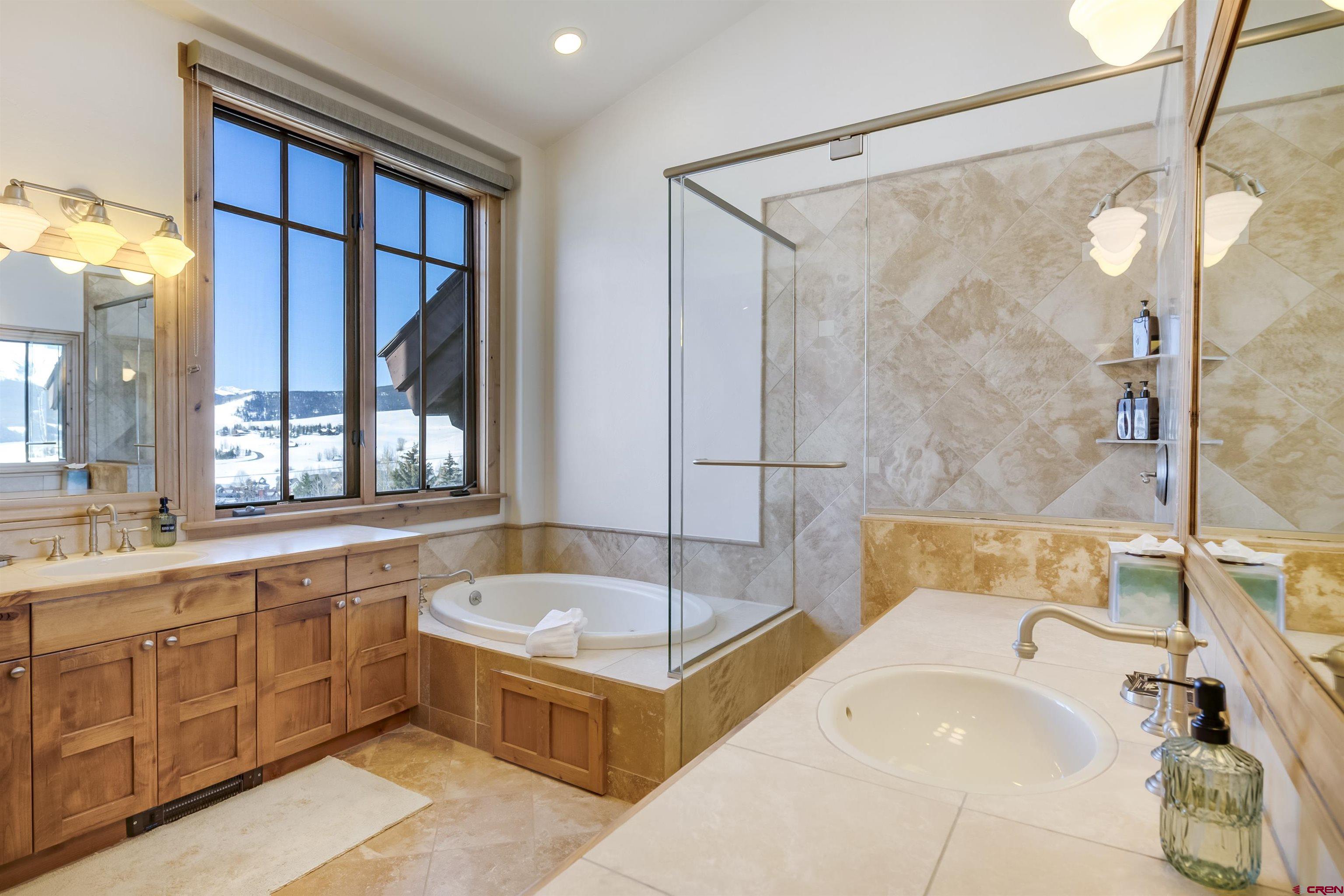 14 Hunter Hill Road, Unit C302 Crested Butte, CO 81225 - Photo 17 of 32 a bathroom with a tub a sink and a large mirror