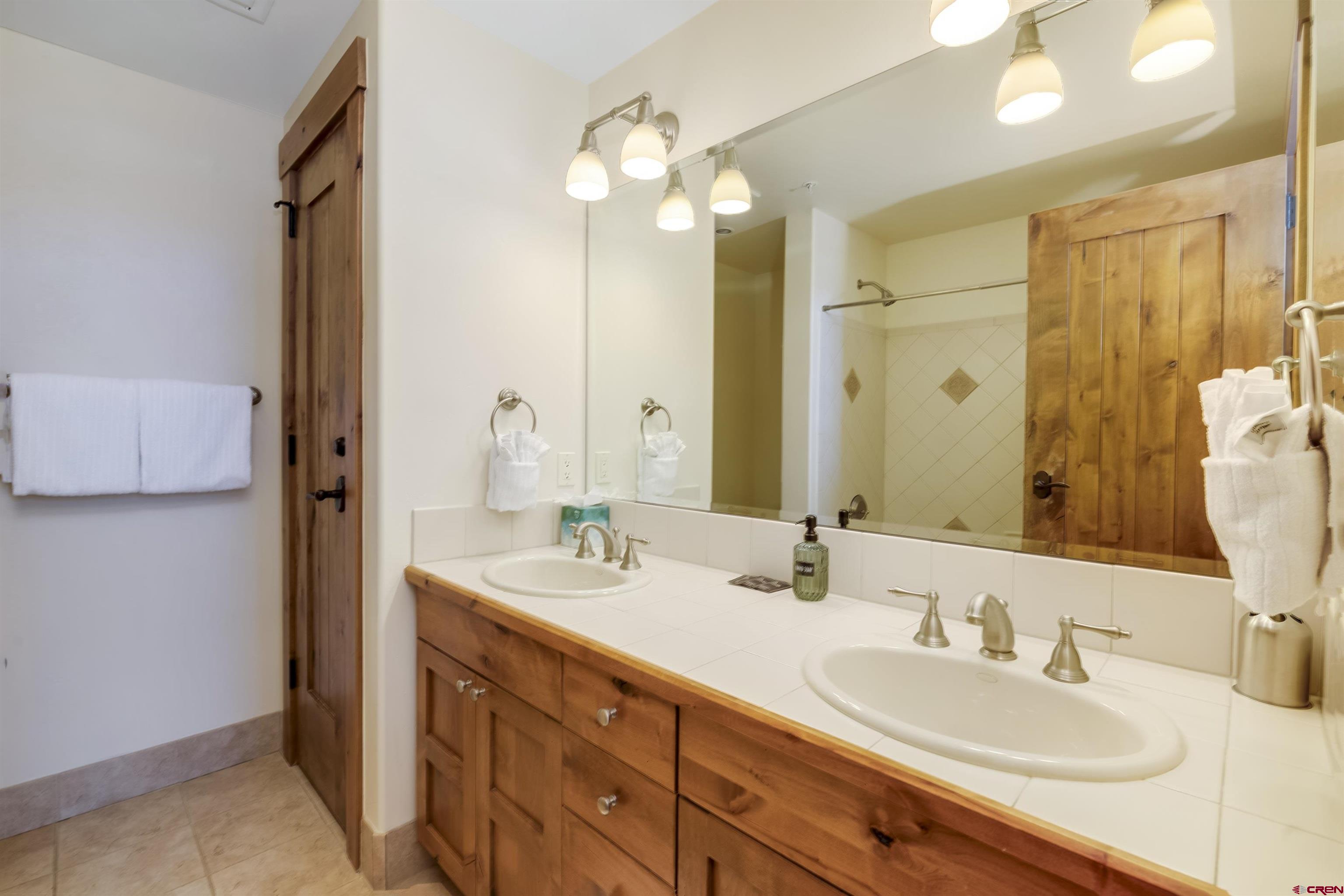 14 Hunter Hill Road, Unit C302 Crested Butte, CO 81225 - Photo 19 of 32 a bathroom with a double vanity sink and a mirror