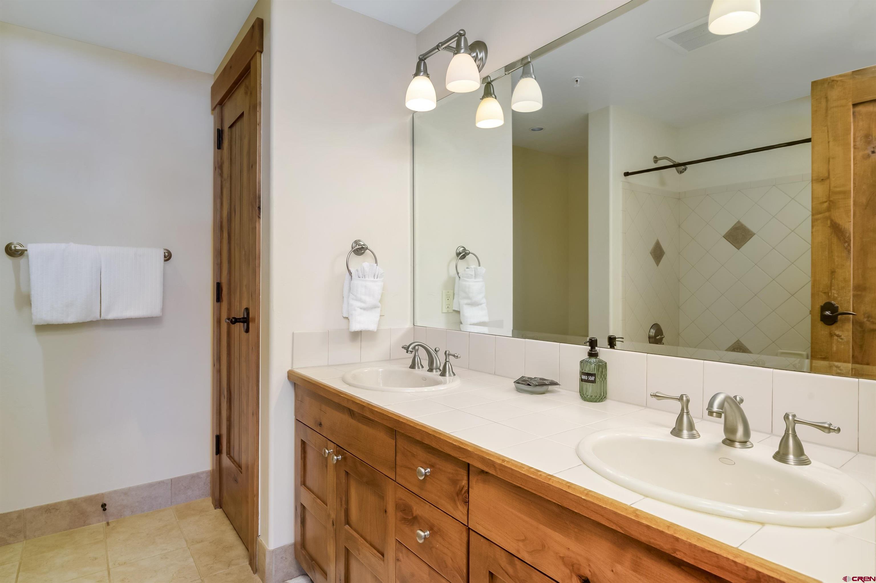 14 Hunter Hill Road, Unit C302 Crested Butte, CO 81225 - Photo 21 of 32 a bathroom with a double vanity sink and a mirror