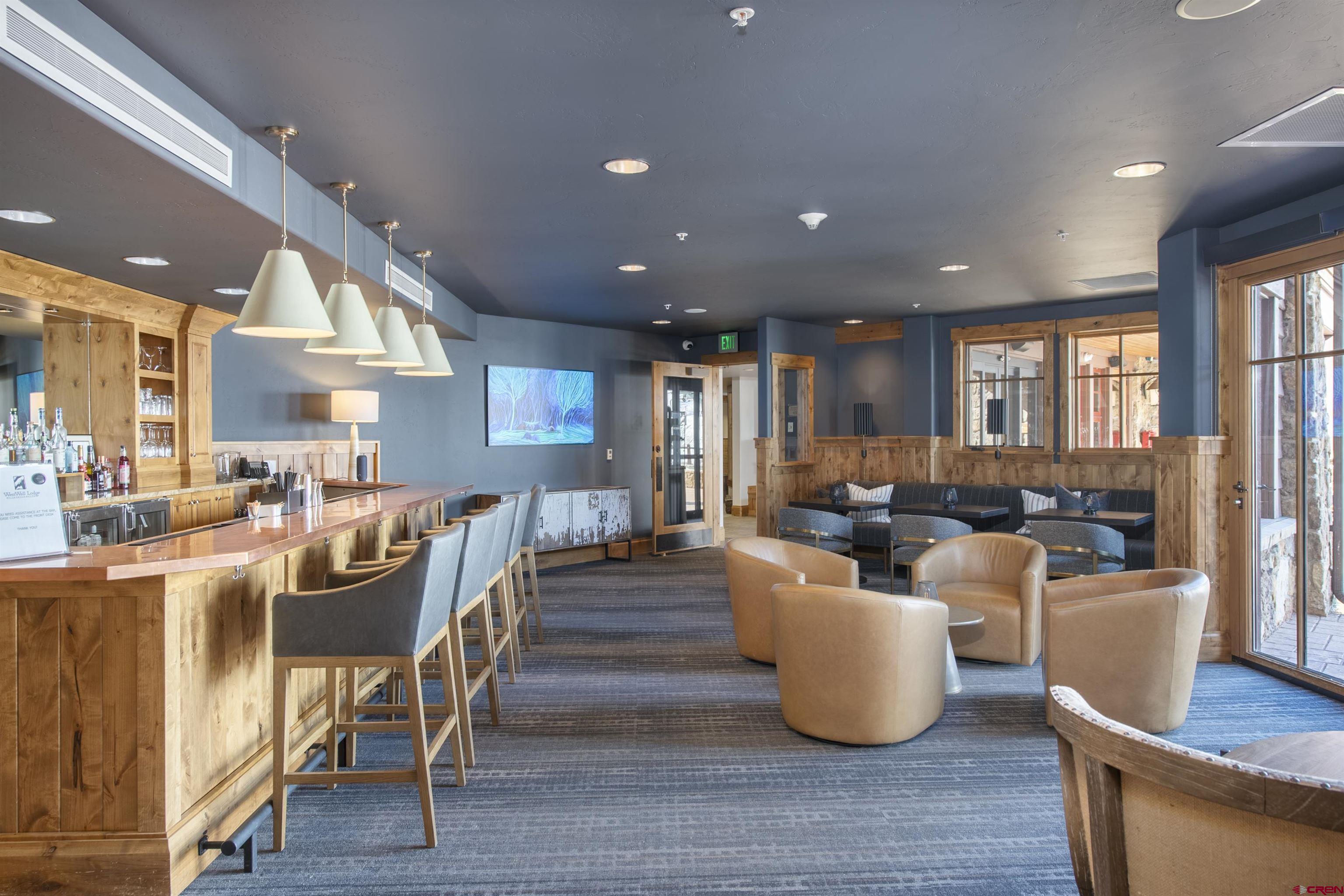 14 Hunter Hill Road, Unit C302 Crested Butte, CO 81225 - Photo 22 of 32 a living room with couches and a dining table with wooden floor
