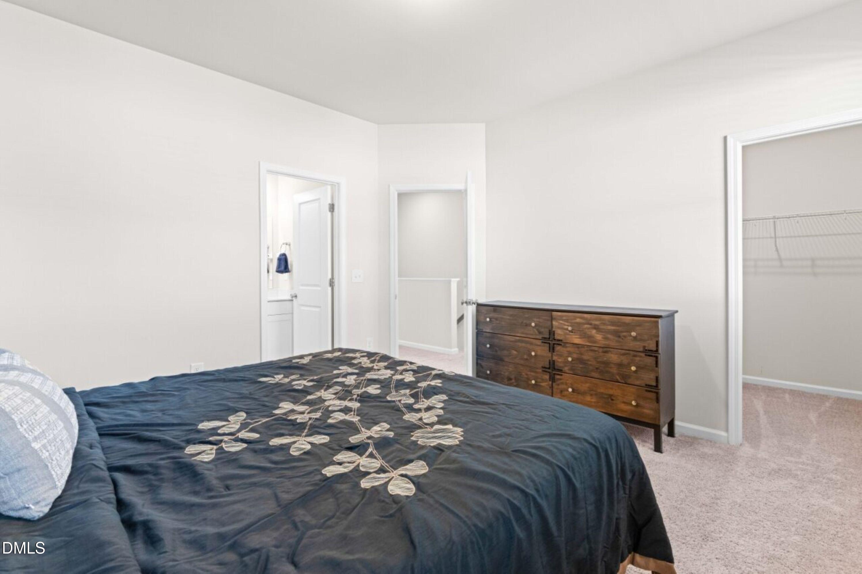 74 Liam Street Clayton, NC 27520 - Photo 22 of 33 a bedroom with a bed and a mirror