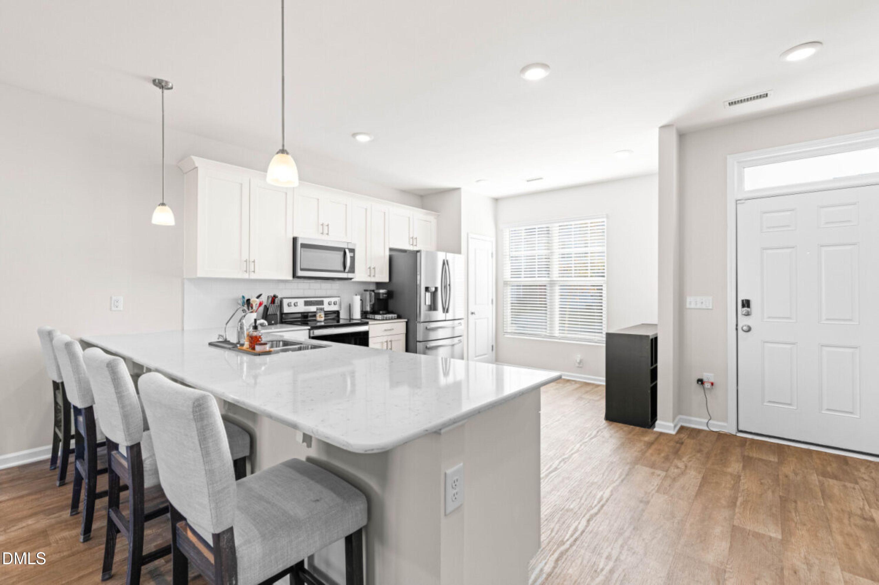 74 Liam Street Clayton, NC 27520 - Photo 9 of 33 a kitchen with a table chairs refrigerator and microwave
