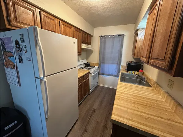 a kitchen with stainless steel appliances a refrigerator stove and wooden floor