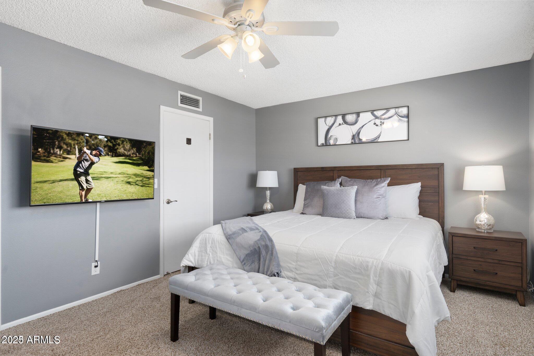 6921 East Osborn Road, Unit D Scottsdale, AZ 85251 - Photo 3 of 14 a bedroom with a bed and painting on the wall