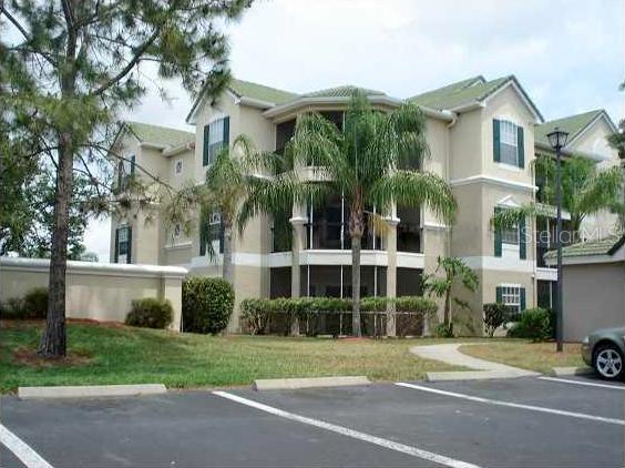 5110 Northridge Road, Unit 201 Sarasota, FL 34238 - Photo 1 of 1 a view of a white building among the street with palm trees