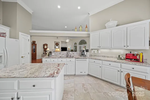 a kitchen with granite countertop a sink and cabinets