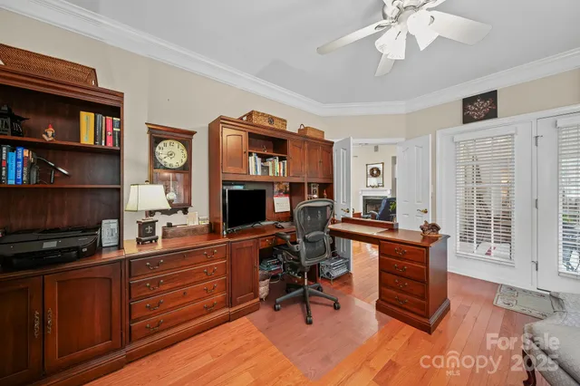 a work room with furniture a flat screen tv and a fireplace