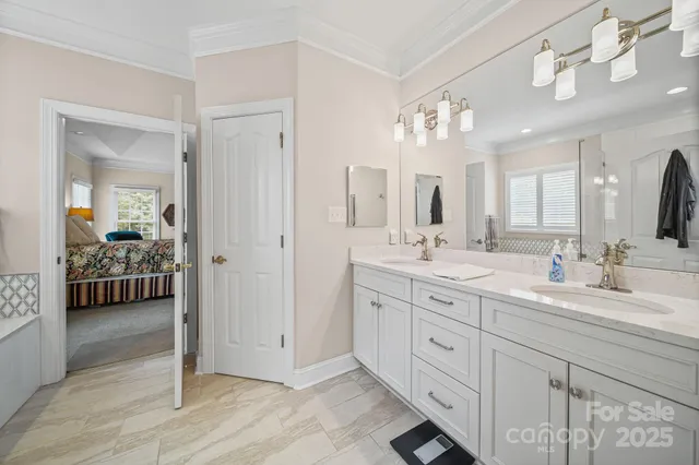 a spacious en suite bathroom with double sink and a mirror