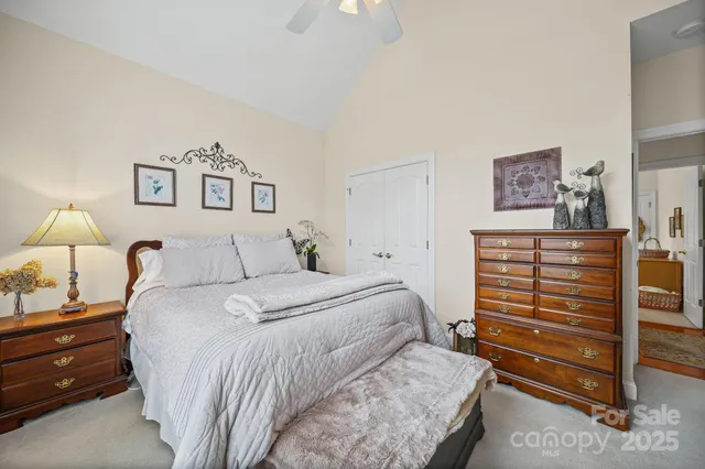 a bedroom with a bed and a lamp on dresser