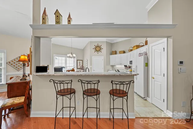 a dining hall with stainless steel appliances kitchen island a table and chairs