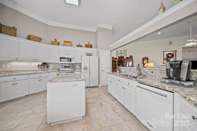 a kitchen with granite countertop cabinets sink and white appliances
