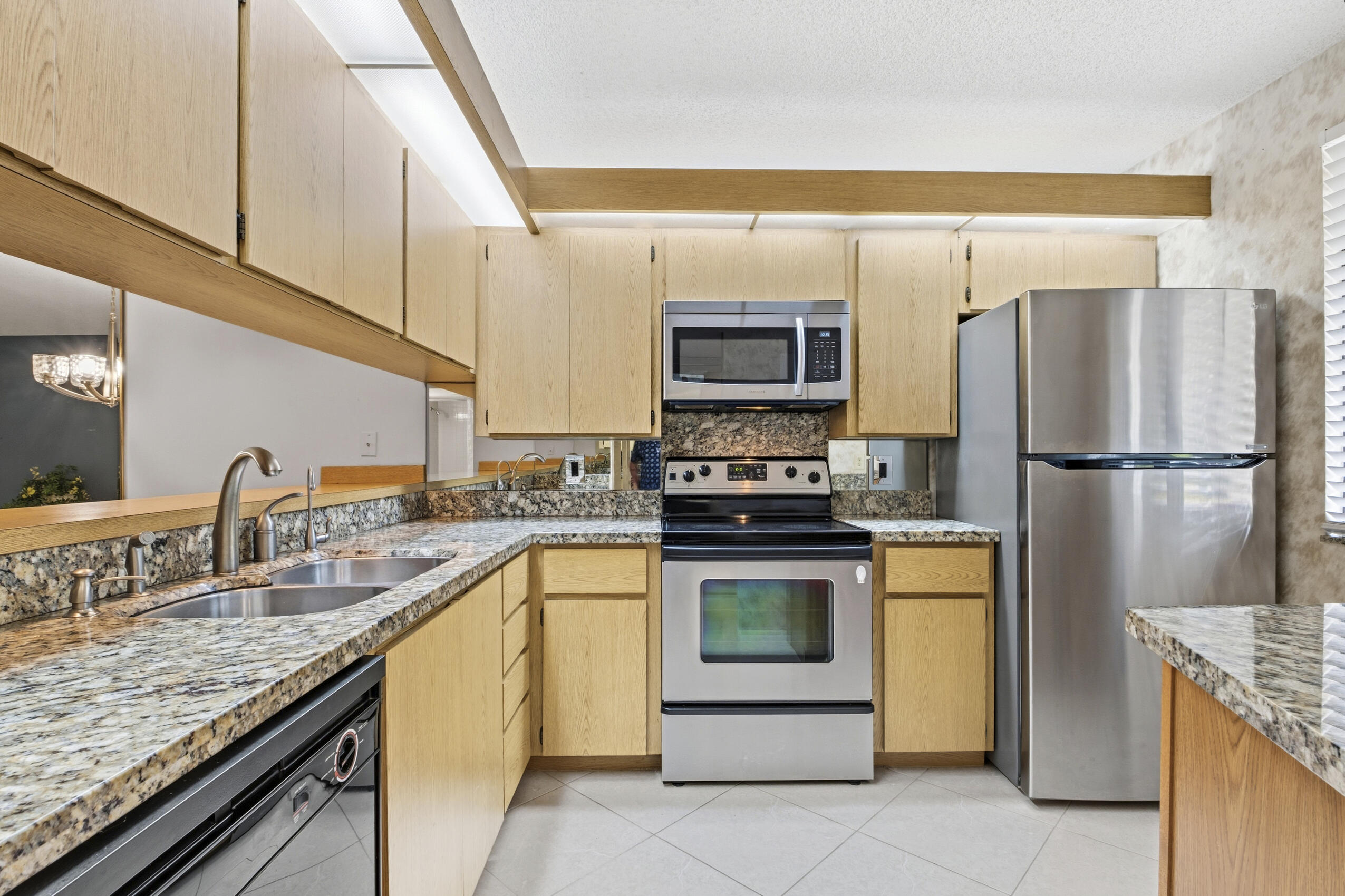 6145 Balboa Circle, Unit 103 Boca Raton, FL 33433 - Photo 4 of 31 a kitchen with stainless steel appliances granite countertop a sink stove and refrigerator