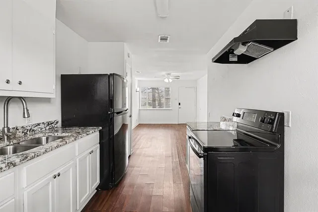 a kitchen with a sink appliances and cabinets