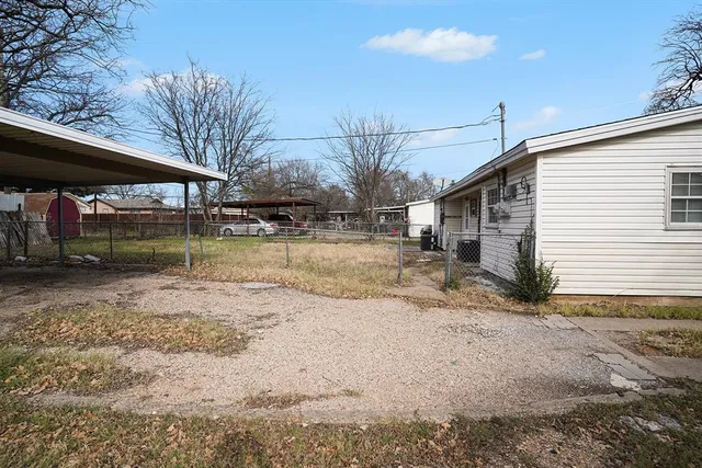 a view of a yard with wooden fence