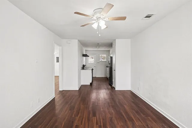 a view of a kitchen with wooden floor and a ceiling fan