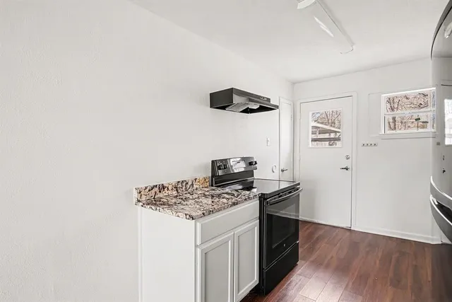 a kitchen with a refrigerator and a stove top oven