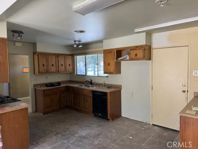 a kitchen with stainless steel appliances granite countertop a refrigerator a sink and a stove