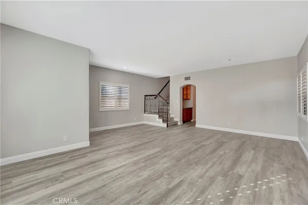 an empty room with wooden floor and window
