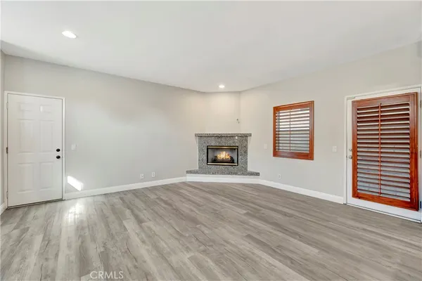 an empty room with windows and fireplace