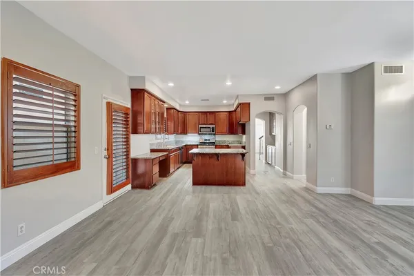 a large kitchen with stainless steel appliances kitchen island a large counter top and a wooden floors