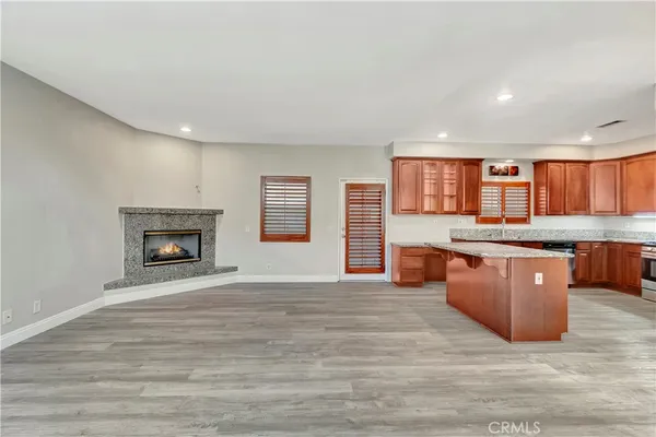 a large kitchen with stainless steel appliances granite countertop a stove and a wooden floors