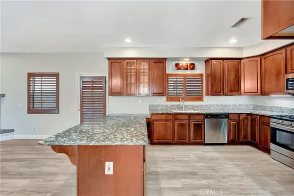 a kitchen with stainless steel appliances granite countertop a stove a sink and a microwave