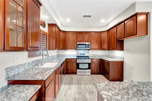 a kitchen with stainless steel appliances granite countertop a sink stove and refrigerator