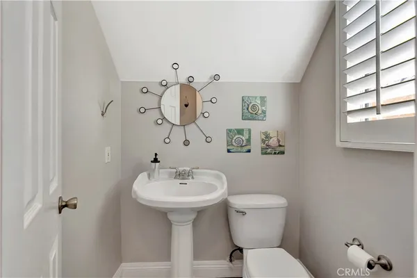 a bathroom with a sink mirror and toilet