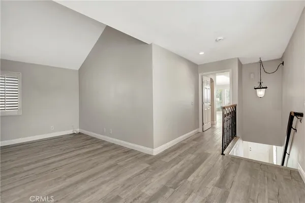 a view of hallway with a large mirror and a hardwood