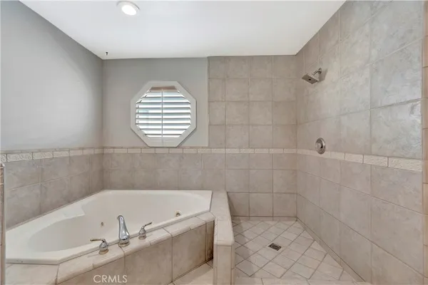 a bathroom with a tub a window and a shower