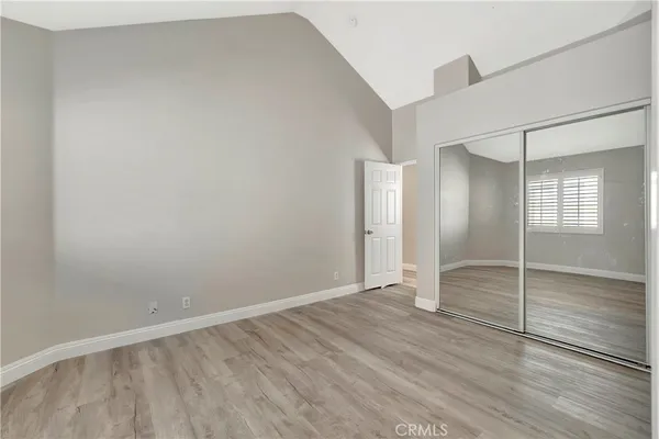 an empty room with wooden floor and mirror