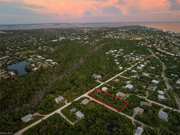 an aerial view of residential houses with outdoor space and trees