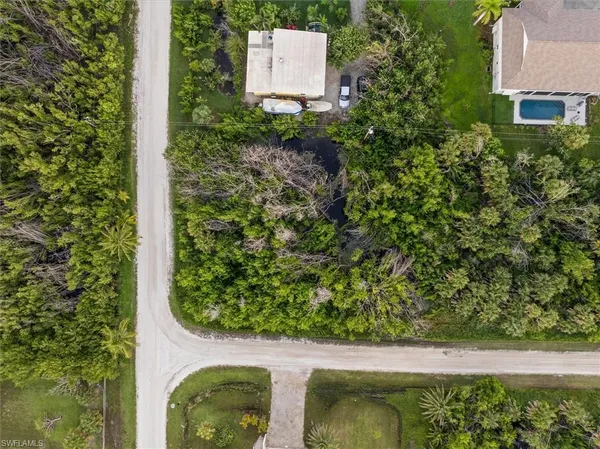 an aerial view of residential house with outdoor space and trees all around