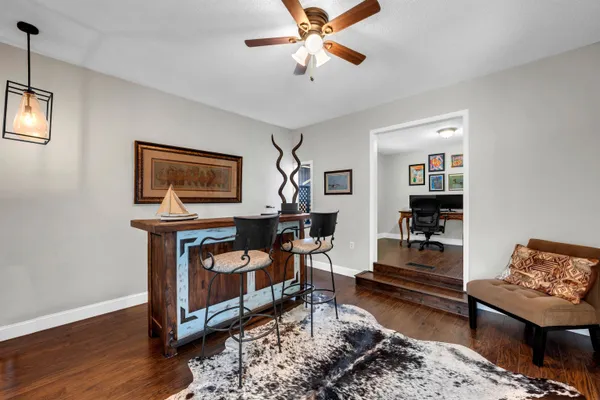 a living room with furniture kitchen view and a flat screen tv