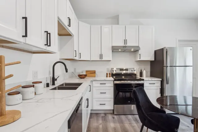 a kitchen with refrigerator a stove and a sink