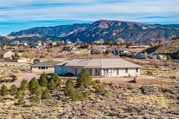 a view of a house with a yard and mountains