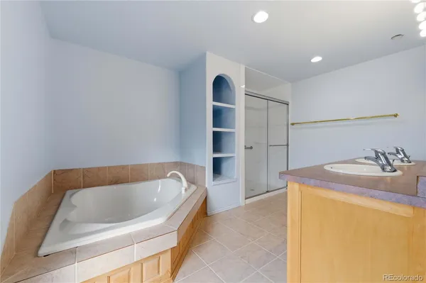 a bathroom with a tub sink and mirror