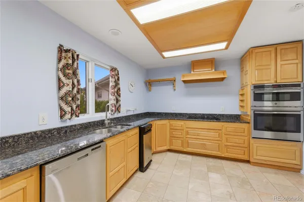 a kitchen with stainless steel appliances granite countertop a sink and dishwasher a stove with wooden floor