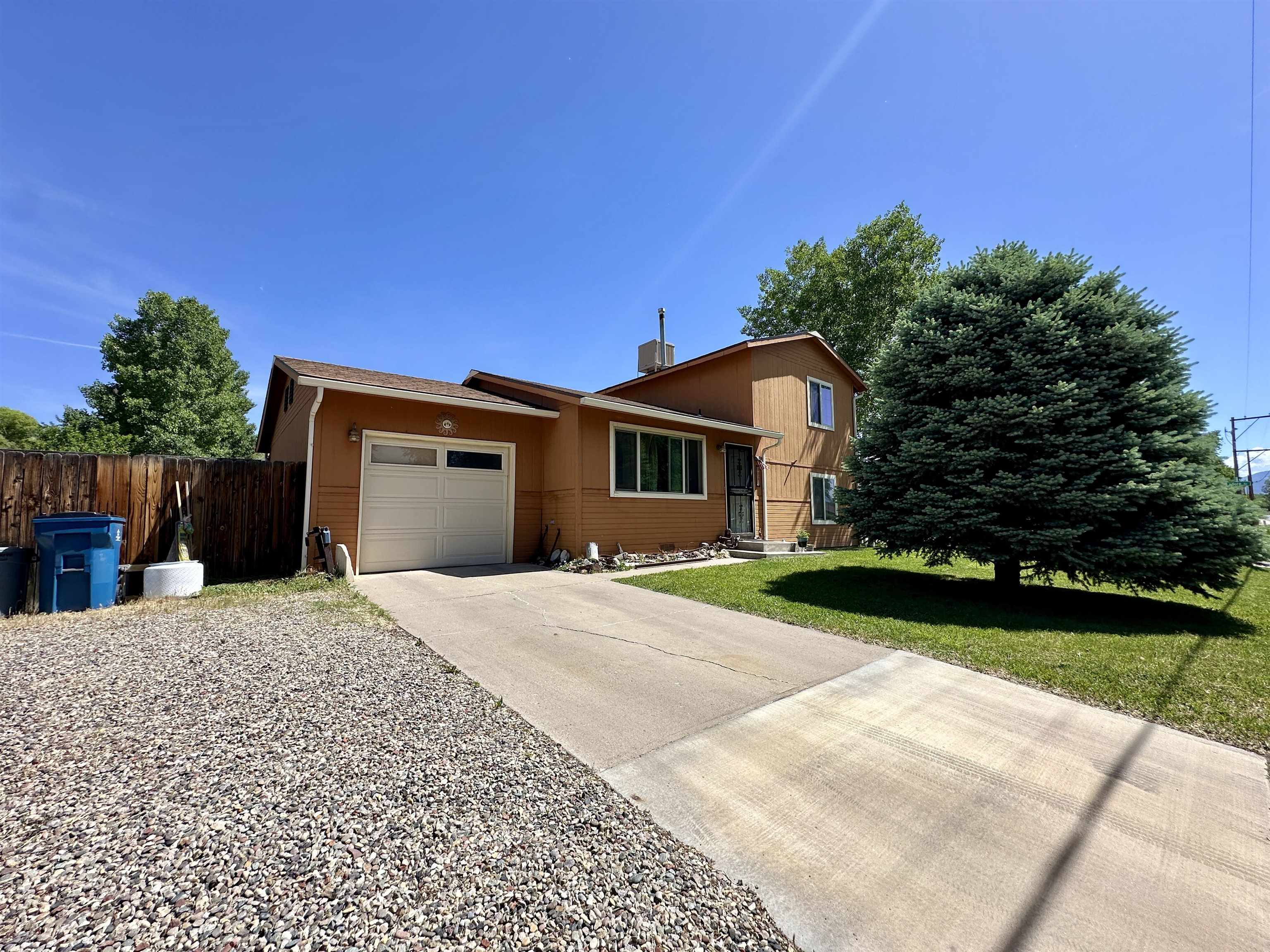 3010 F F 3/4 Road Grand Junction, CO 81504 - Photo 1 of 25 a front view of a house with a yard and a garage