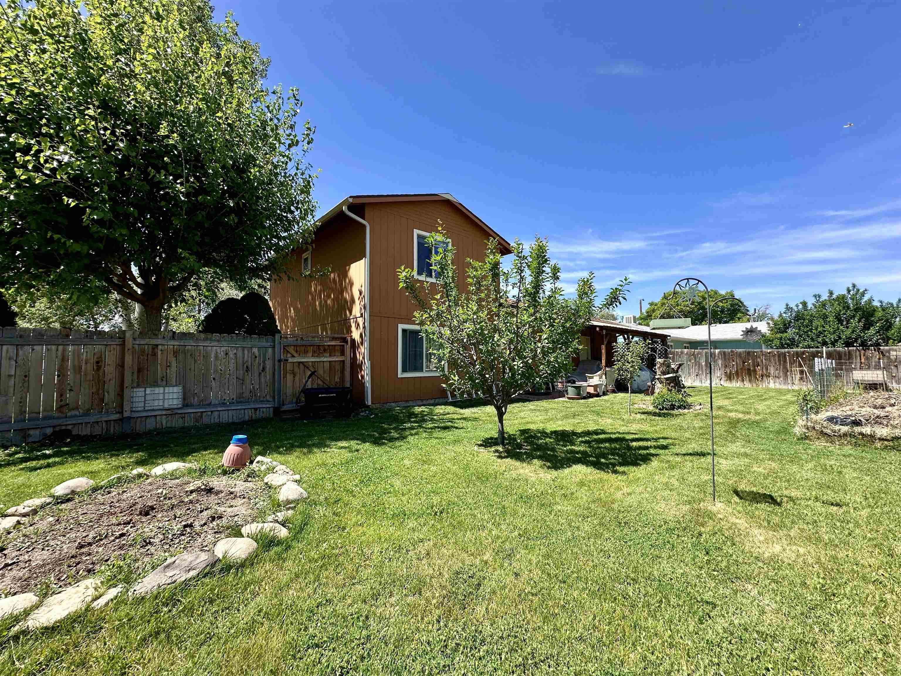 3010 F F 3/4 Road Grand Junction, CO 81504 - Photo 19 of 25 a backyard of a house with plants and wooden fence
