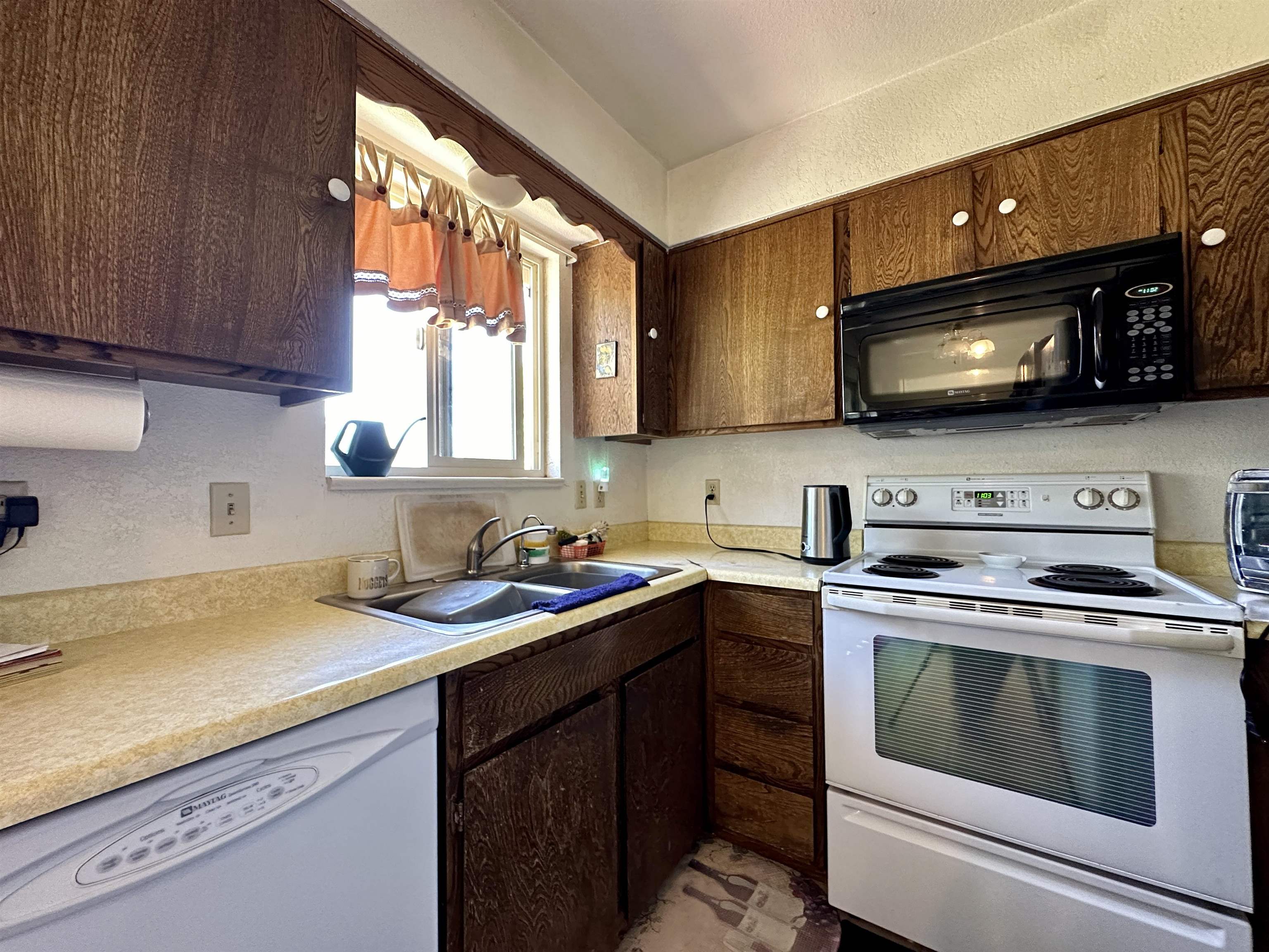 3010 F F 3/4 Road Grand Junction, CO 81504 - Photo 7 of 25 a kitchen with a stove a sink a microwave and cabinets