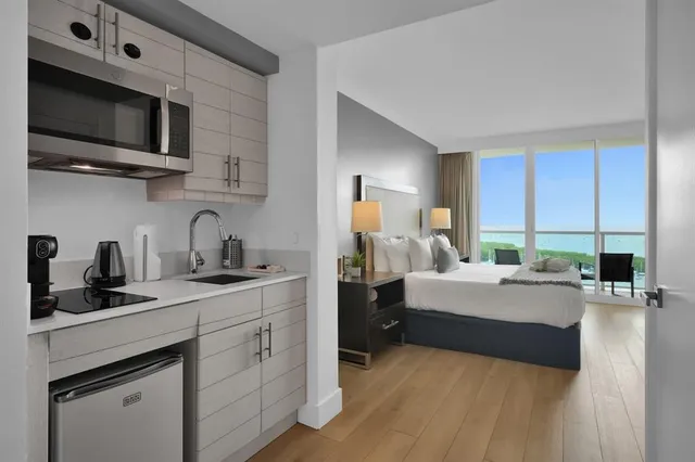 a bedroom with a bed a flat screen tv and windows