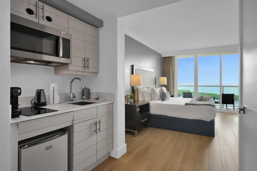 2889 McFarlane Road, Unit 1516 Miami, FL 33133 - Photo 2 of 18 a bedroom with a bed a flat screen tv and windows