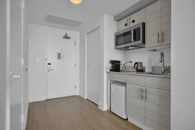 a kitchen with cabinets stainless steel appliances and sink