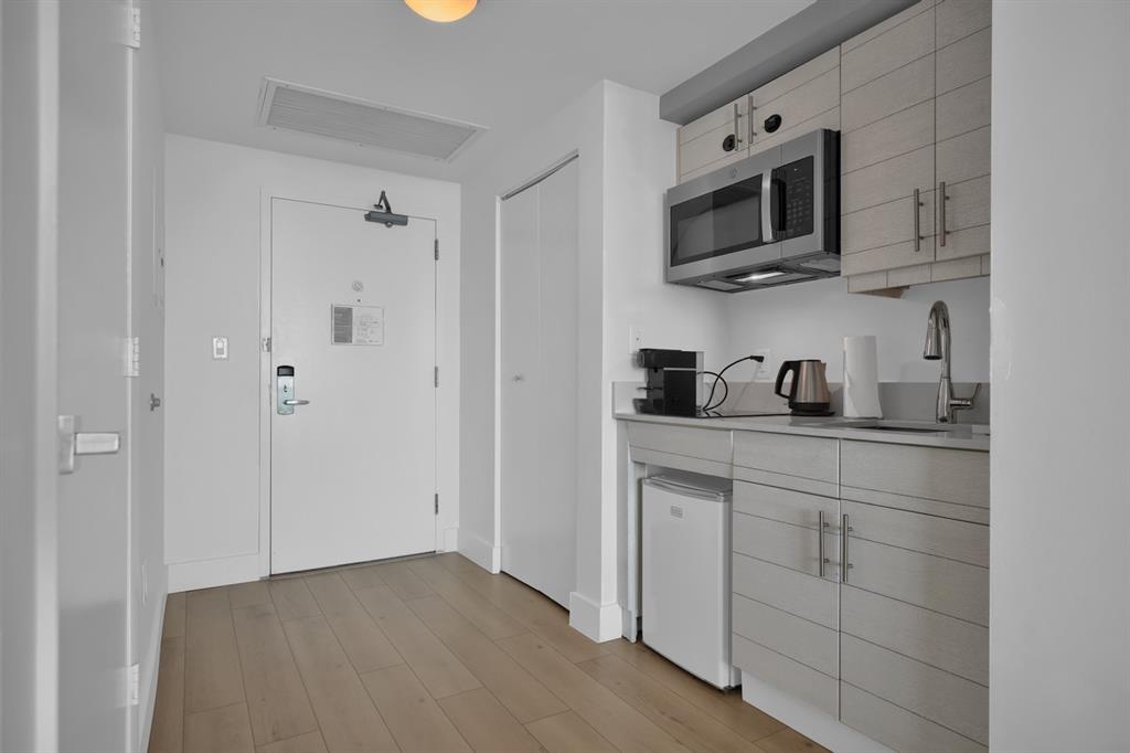 2889 McFarlane Road, Unit 1516 Miami, FL 33133 - Photo 3 of 18 a kitchen with cabinets stainless steel appliances and sink